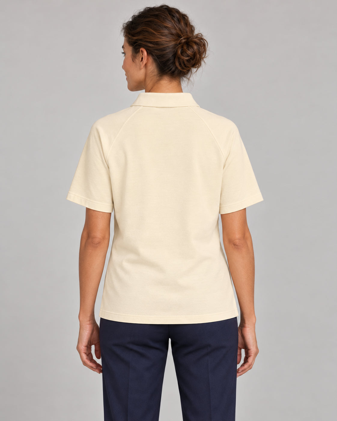 Woman wearing Putting dachshund golf polo, back studio view. Color: Apricot