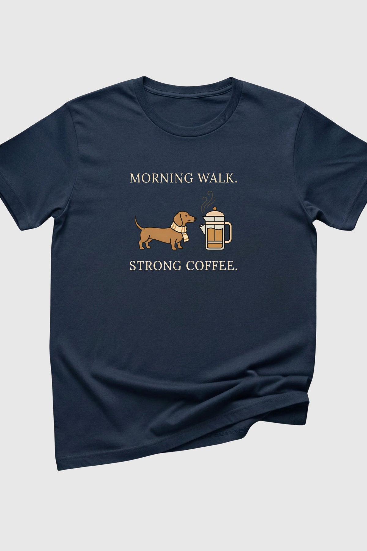 Navy blue t-shirt with a graphic of a dog and coffee cup and text 'Morning walk. Strong coffee.' on a light gray background.