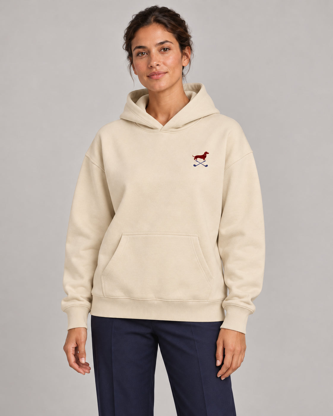 Woman wearing Club & Swing dachshund golf hoodie, front studio view. Color: Apricot