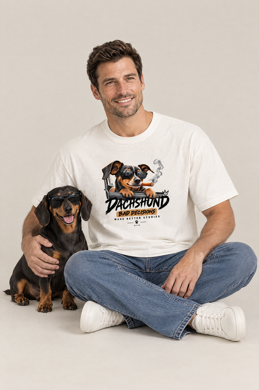 Man sitting on the floor with a black and tan dachshund in sunglasses in the white Bad Decisions Dachshund Tee. Color: White