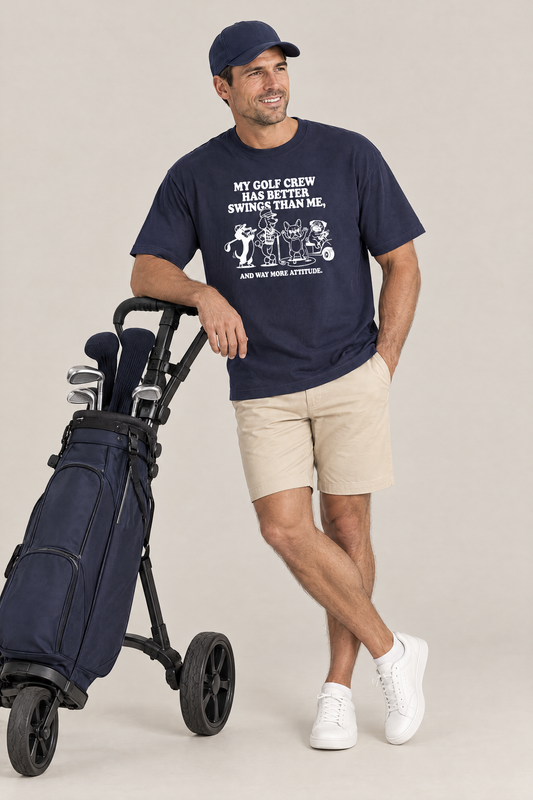Man leaning on a golf push trolley in the navy Better Swings Dog Golf Tee. Color: Navy