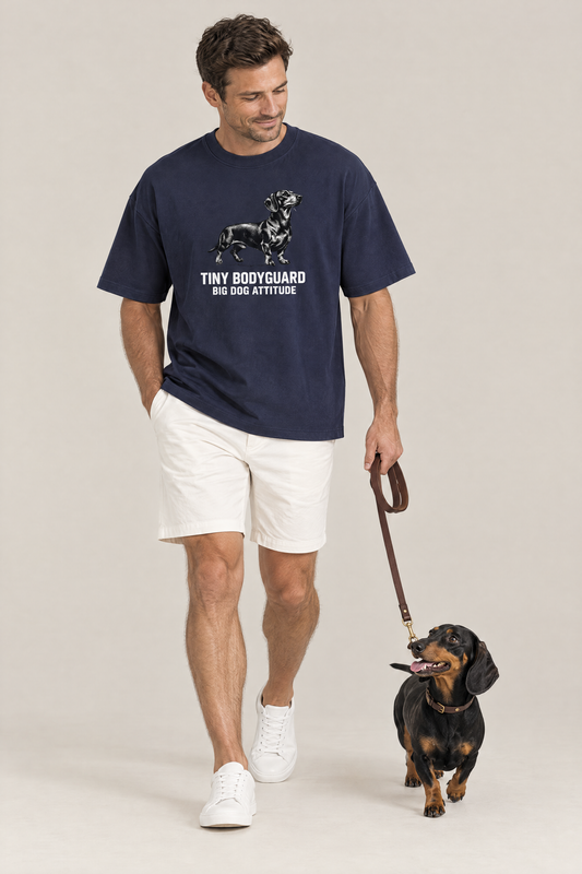 Man walking a black and tan dachshund on a leash in the navy Big Dog Attitude Dachshund Tee. Color: Navy