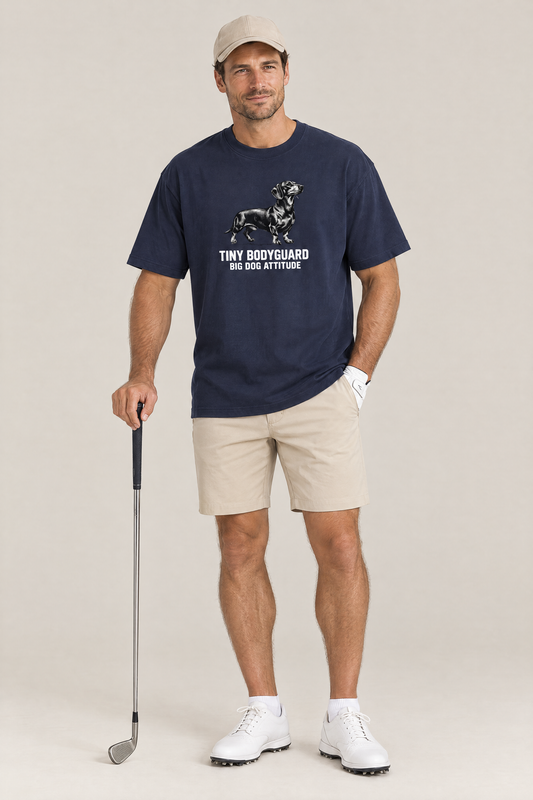 Man in a beige cap holding a golf club in the navy Big Dog Attitude Dachshund Tee. Color: Navy