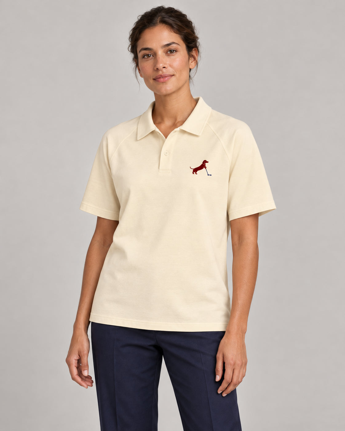 Woman wearing Putting dachshund golf polo, front studio view. Color: Apricot