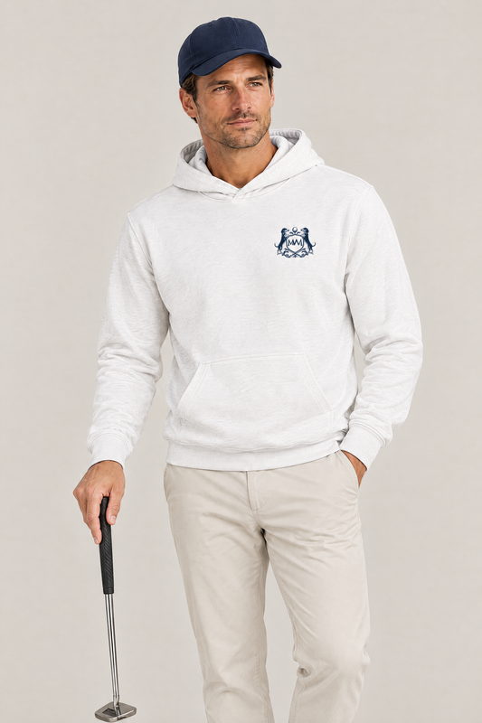 Man holding a putter, wearing the white Club Crest hoodie with the small navy crest on the chest, a navy cap and stone chinos