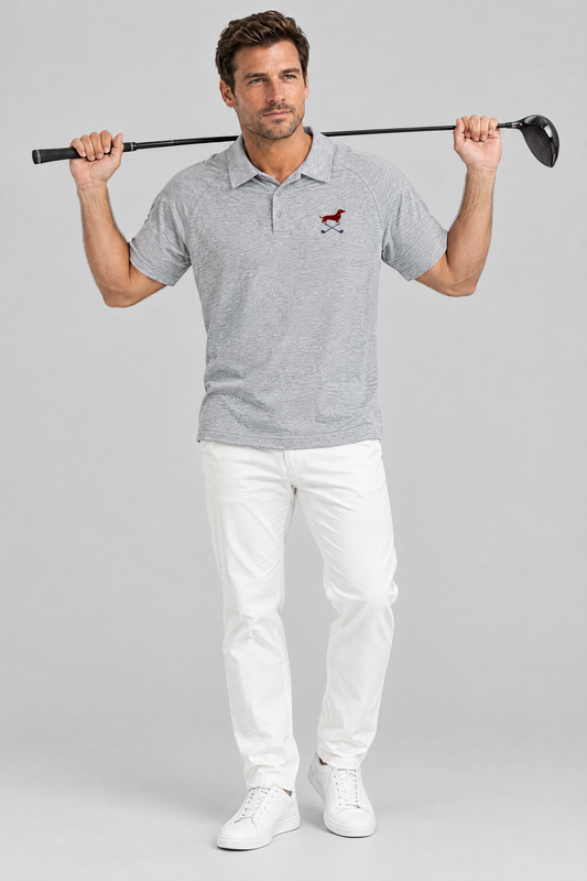 Man holding a driver behind his shoulders in the flower gray Club Mark dachshund golf polo and white chinos. Color: Flower Gray