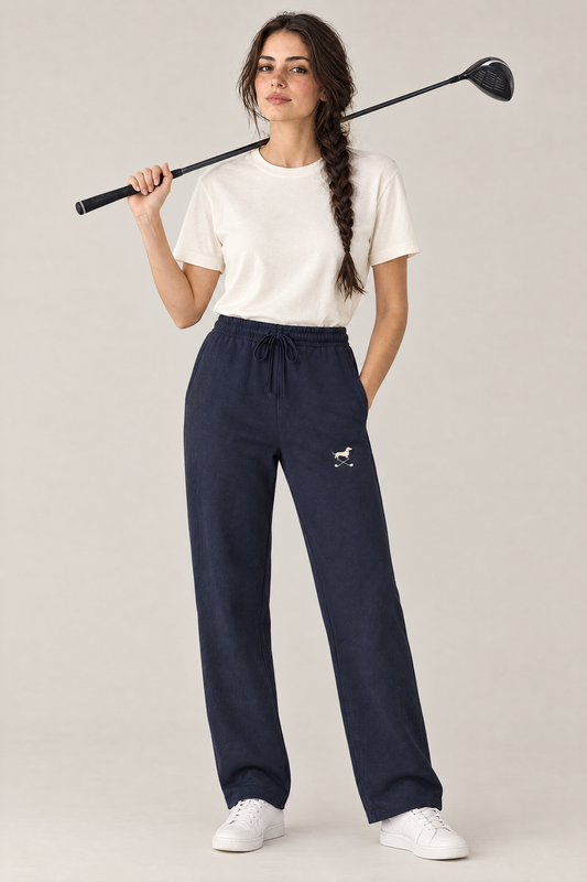Woman holding a driver over her shoulder in navy blue Club Mark dachshund golf sweatpants and a cream tee. Color: Navy Blue