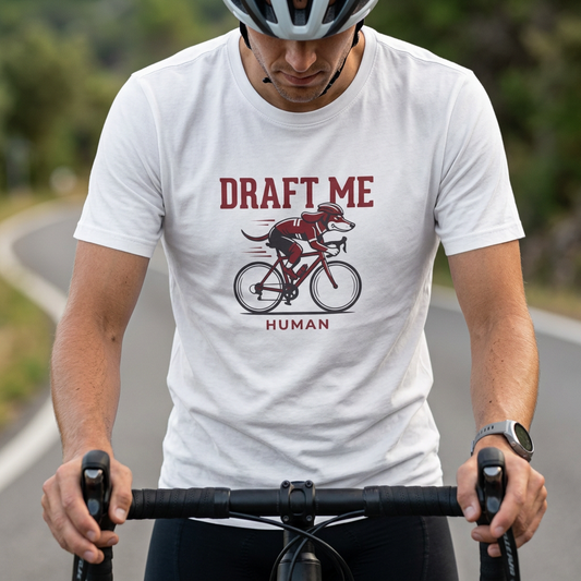 Person riding a bicycle wearing a white t-shirt with a graphic and text.