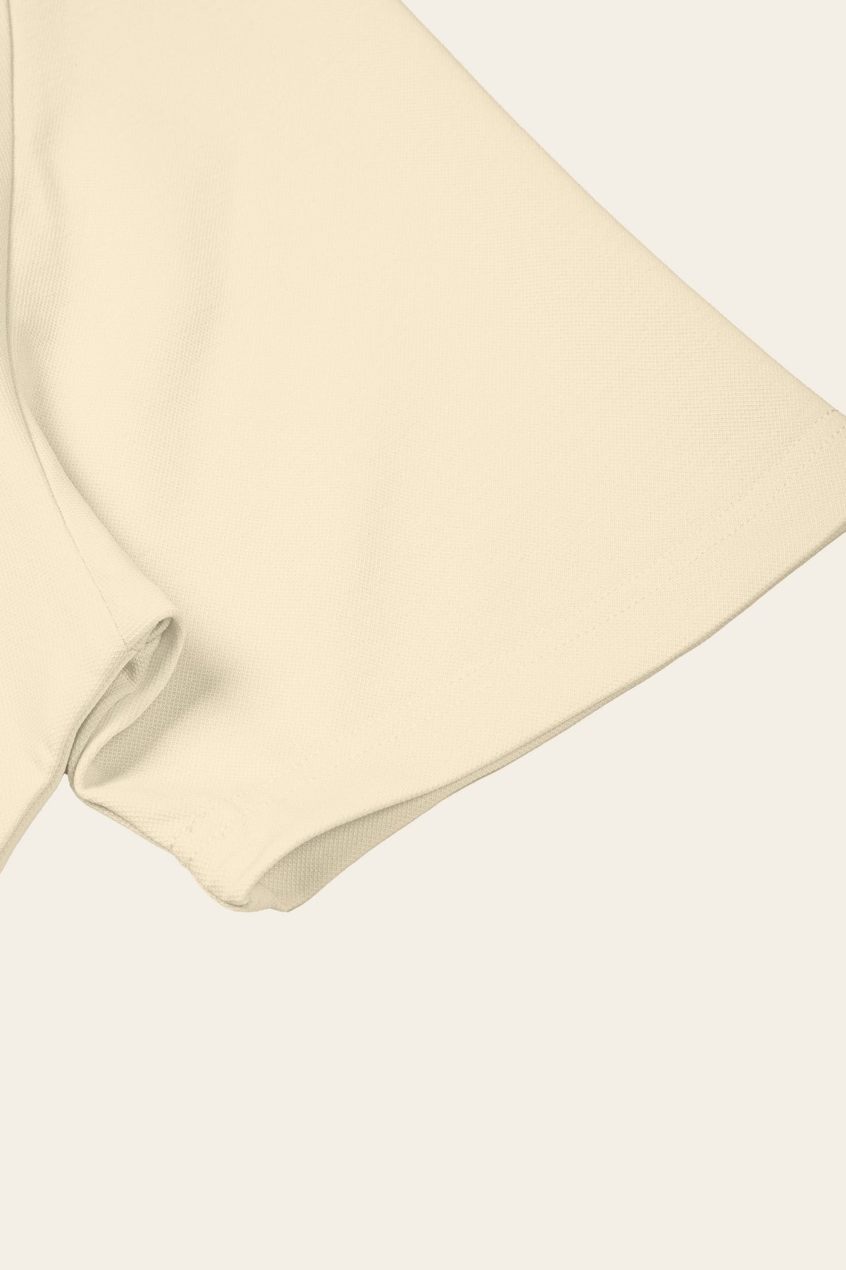 Detail of the short sleeve with stitched hem of the apricot golf polo. Color: Apricot
