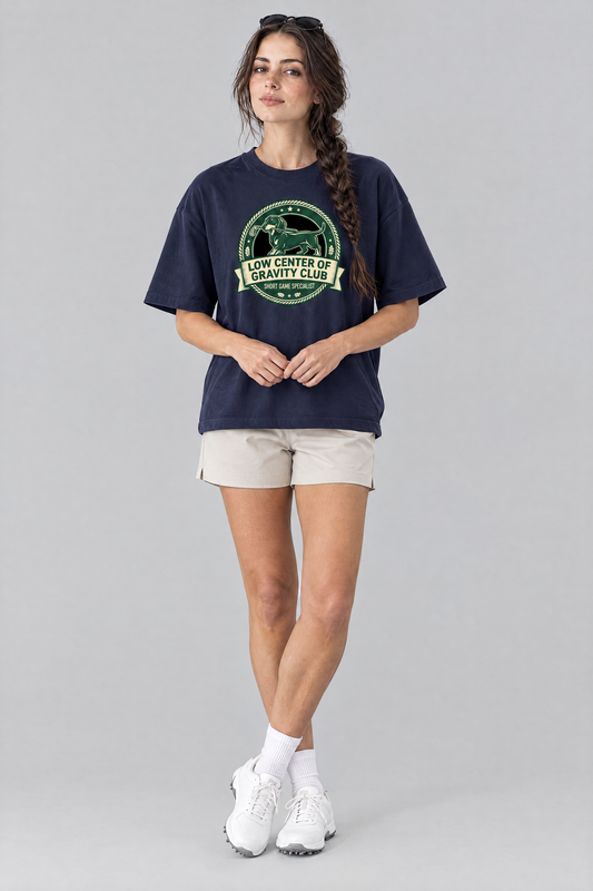 Woman wearing the Low Center of Gravity Club Dachshund Golf Tee in navy with stone golf shorts and sunglasses on her head. Color: Navy