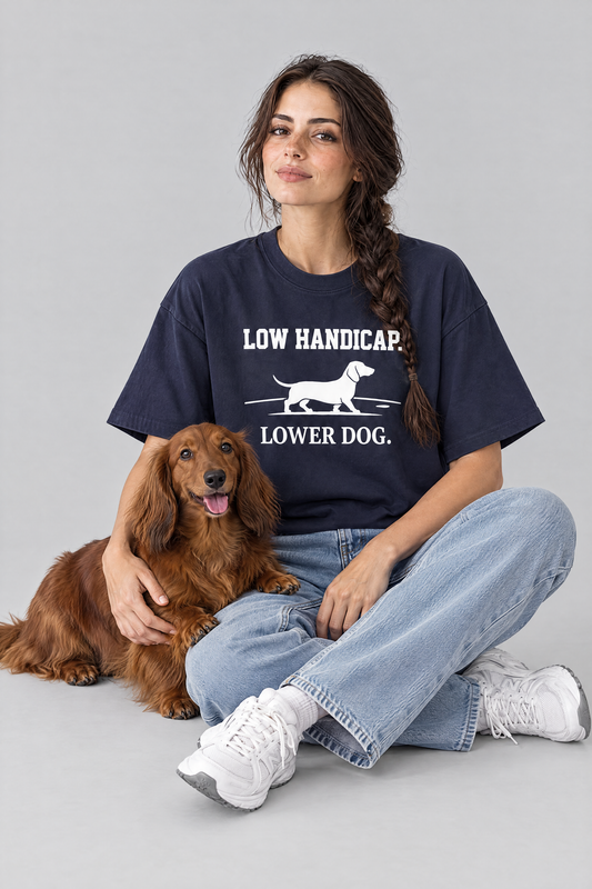 Woman sitting on the floor with a long-haired dachshund in the navy Low Handicap Dachshund Golf Tee. Color: Navy