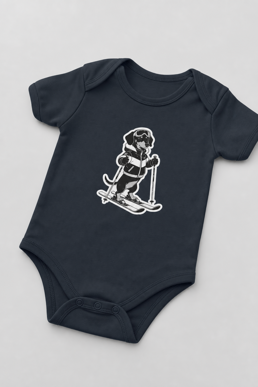 Baby wearing white skiing black labrador bodysuit, snap closure