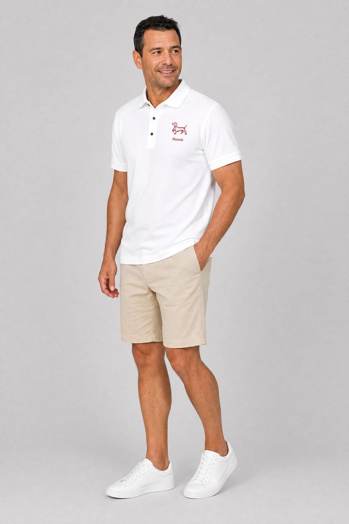 Man wearing black embroidered dachshund polo shirt with dog's name stitched in red, front view