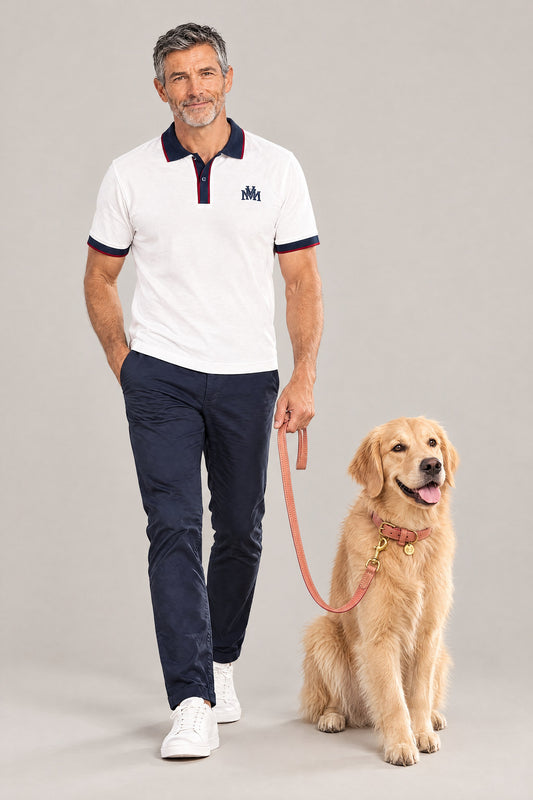 Man in the white Club Crest color block polo with a Golden Retriever on the peach Cloud 7 Tiergarten leash and collar