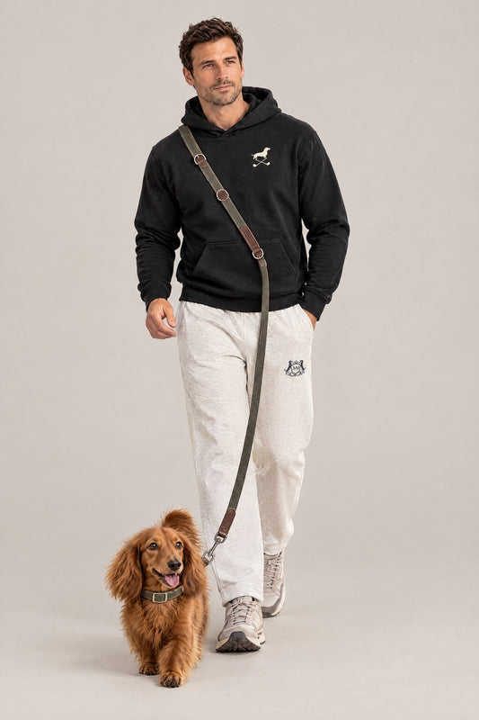 Man in the black Club and Swing dachshund golf hoodie wearing the olive Cloud 7 Tivoli leash hands-free with a long-haired dachshund