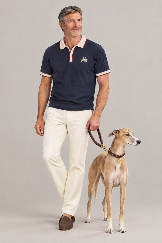 Man in the navy Club Crest color block polo with a whippet wearing the hazel Cloud 7 Ravello collar and braided leash