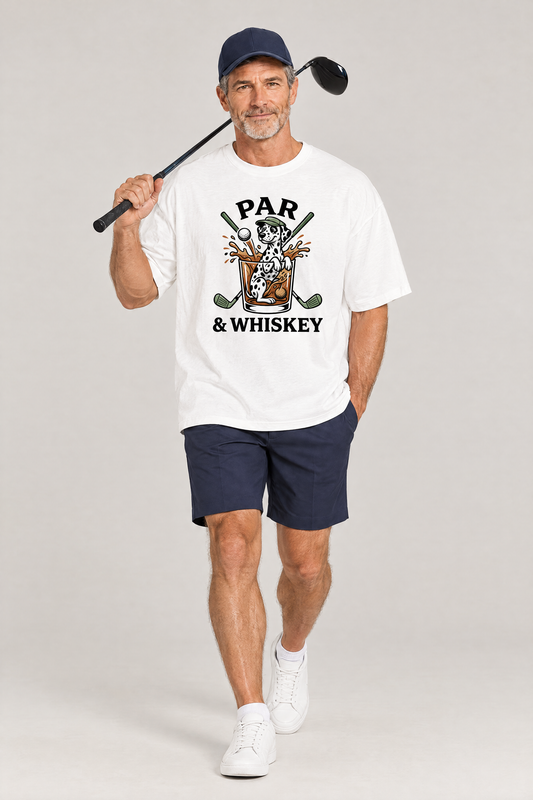 Man walking with a golf driver on his shoulder in the white Par & Whiskey Dalmatian Golf Tee. Color: White