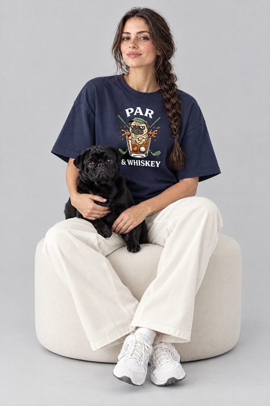 Woman sitting on an ottoman with a black pug in the navy Par & Whiskey Pug Golf Tee. Color: Navy