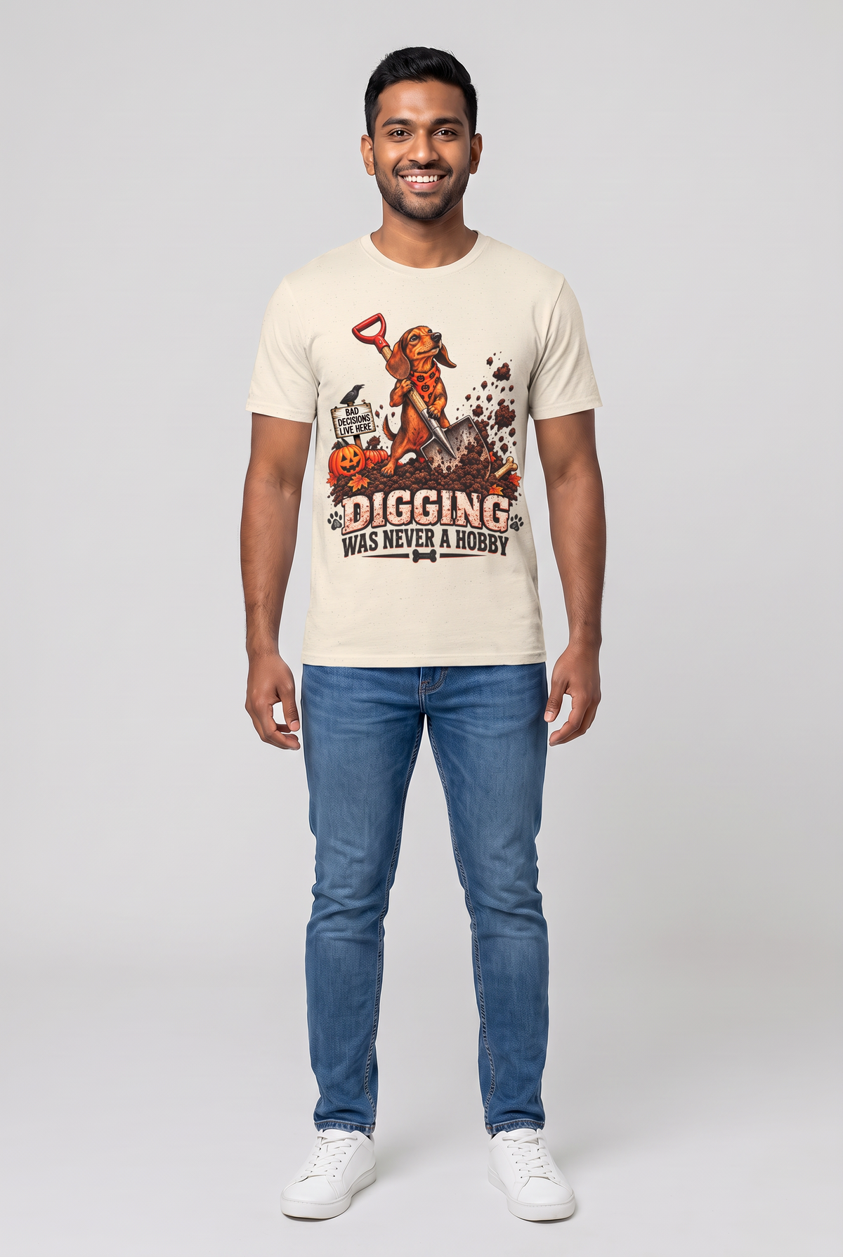 Man wearing a natural funny dachshund Halloween t-shirt with a digging wiener dog and the text Digging Was Never A Hobby, front view