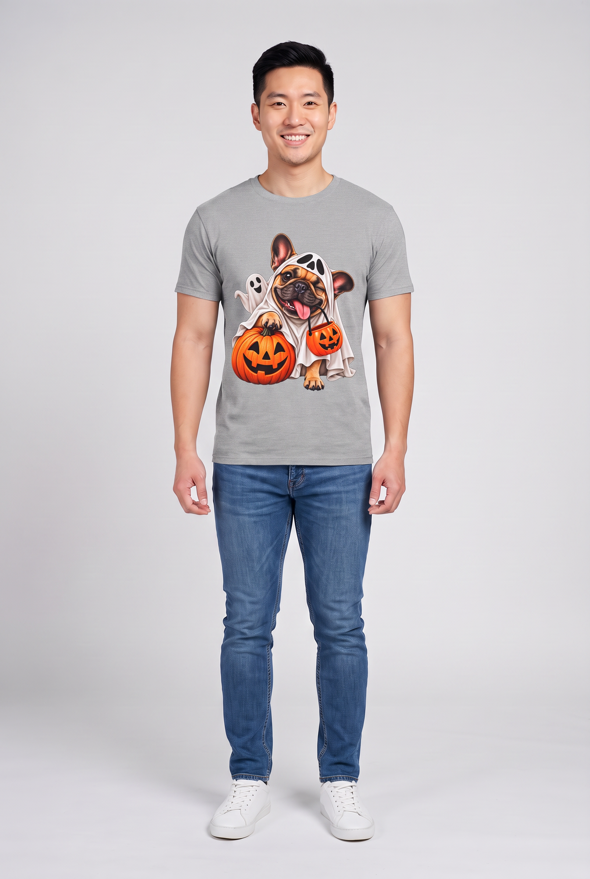 Mann trägt ein Frenchie Gespenster Halloween T-Shirt in Sport Grey mit Französischer Bulldogge im Gespensterkostüm und Kürbis-Süssigkeiteneimer, Vorderansicht