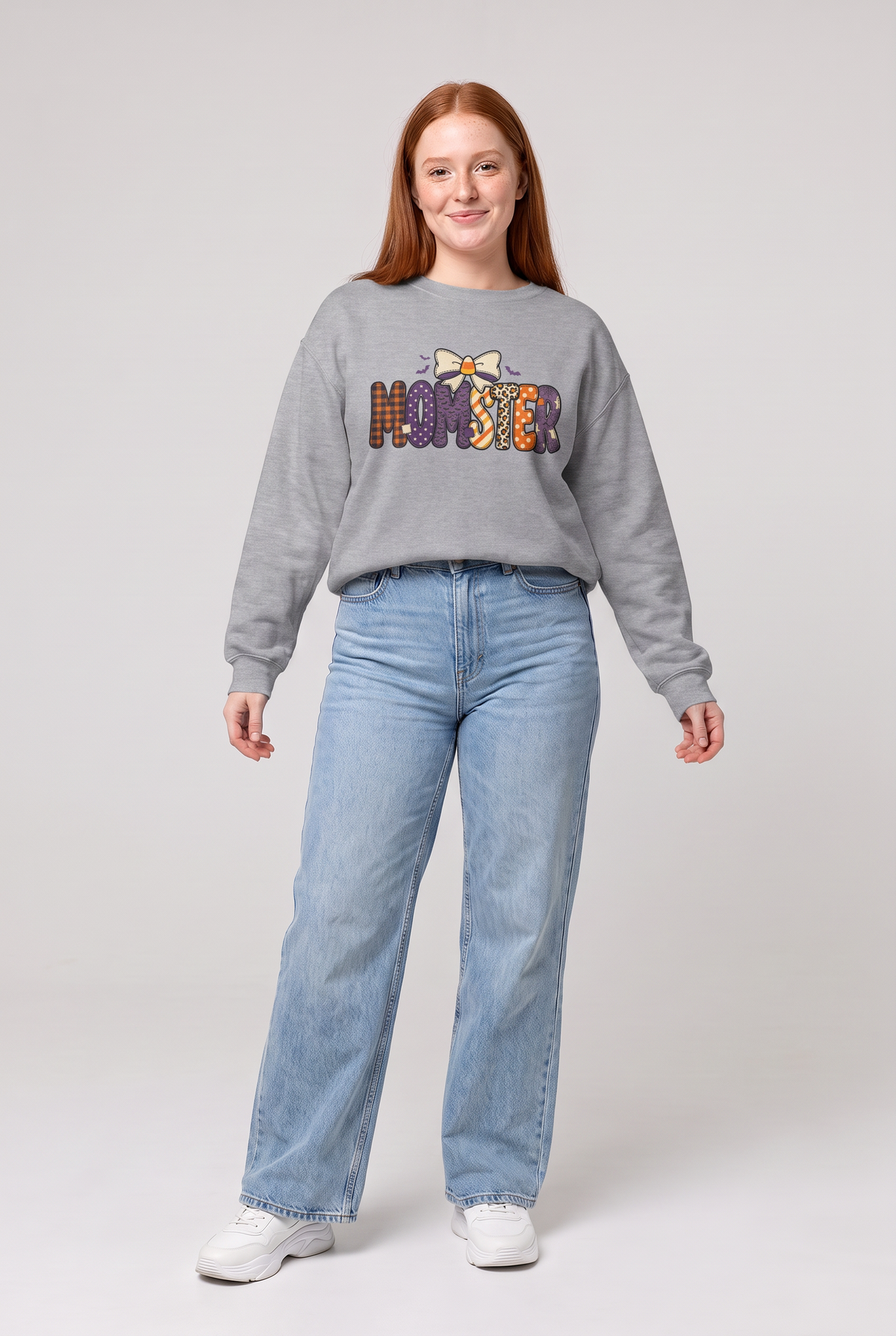 Woman wearing the Momster Halloween sweatshirt in sport grey, front view. Color: Sport Grey
