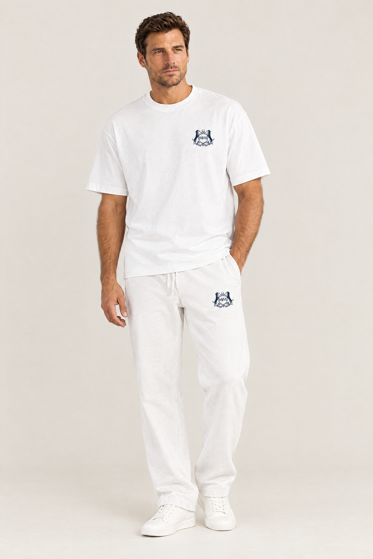 Man in the white oversized Club Crest tee with the small navy Golf & Dachshund Club crest and white sweatpants