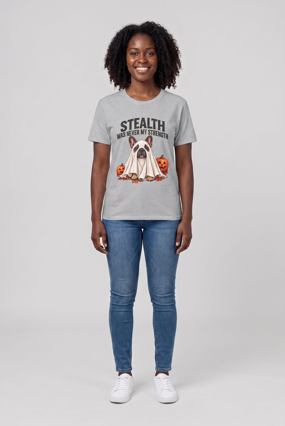 Woman wearing a sport grey French bulldog Halloween t-shirt with a Frenchie ghost and the text Stealth Was Never My Strength, front view