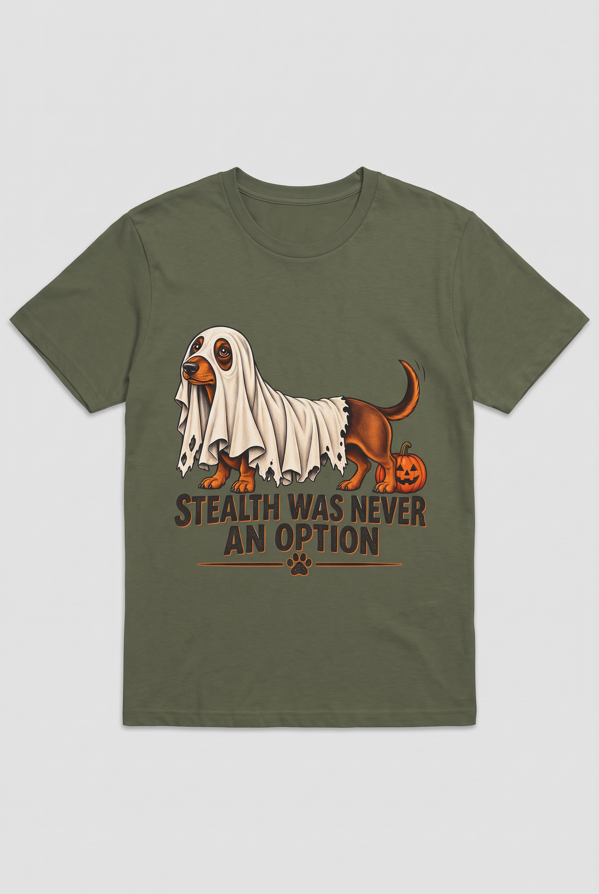 Flat lay of a military green dachshund Halloween t-shirt with a wiener dog under a too-short ghost sheet and the text Stealth Was Never An Option