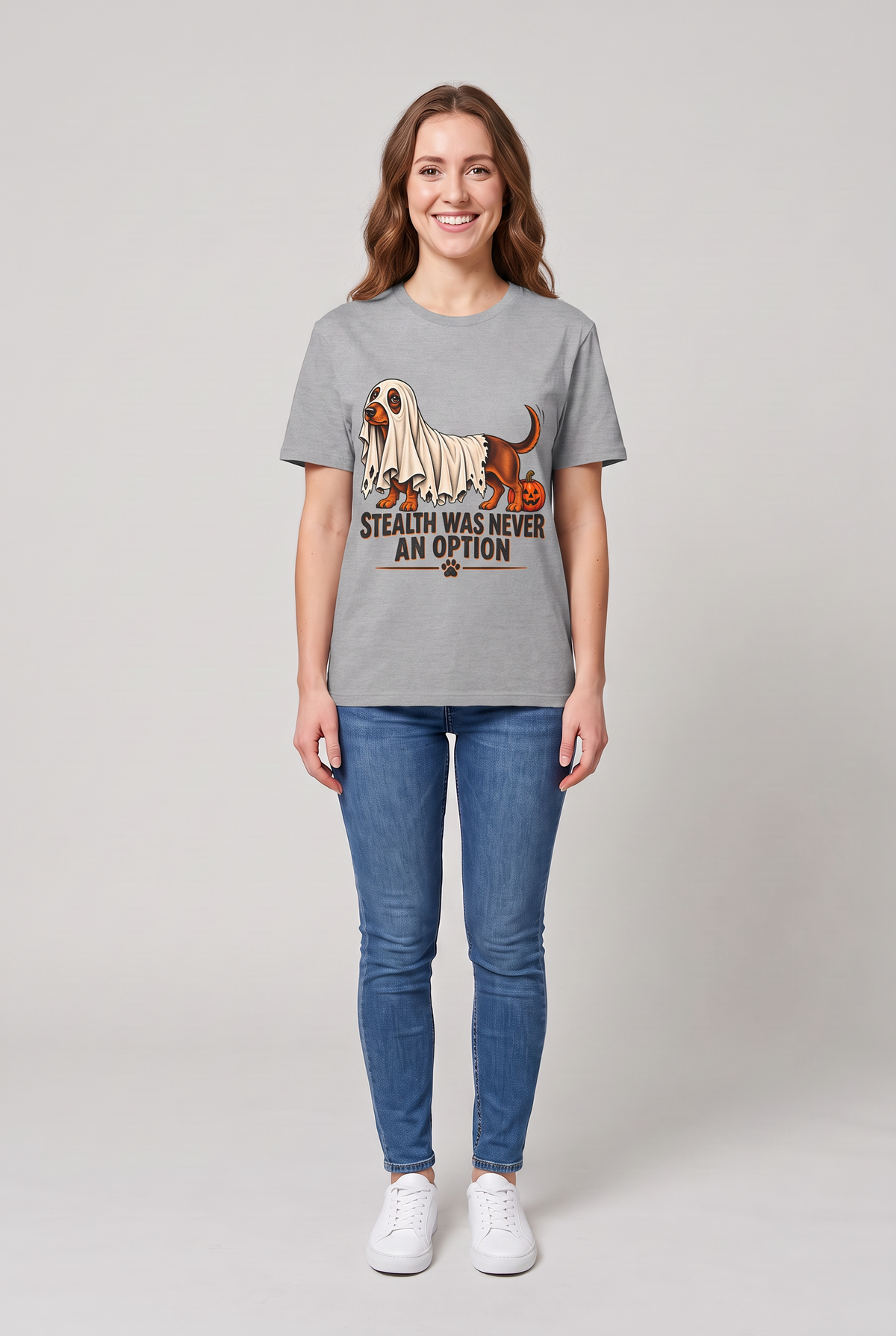 Woman wearing a sport grey dachshund Halloween t-shirt with a wiener dog under a too-short ghost sheet and the text Stealth Was Never An Option, front view