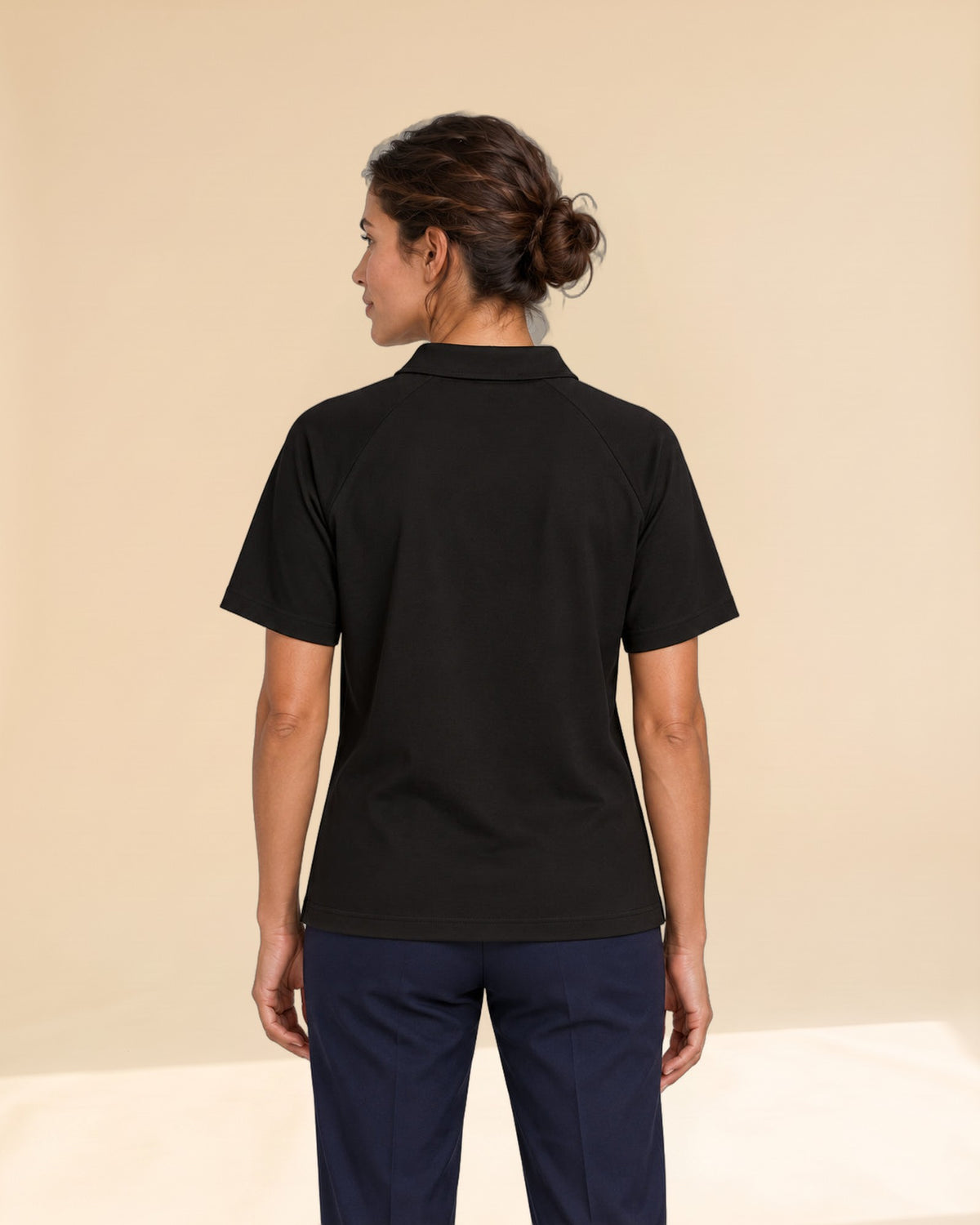 Woman wearing Putting dachshund golf polo, back studio view. Color: Black