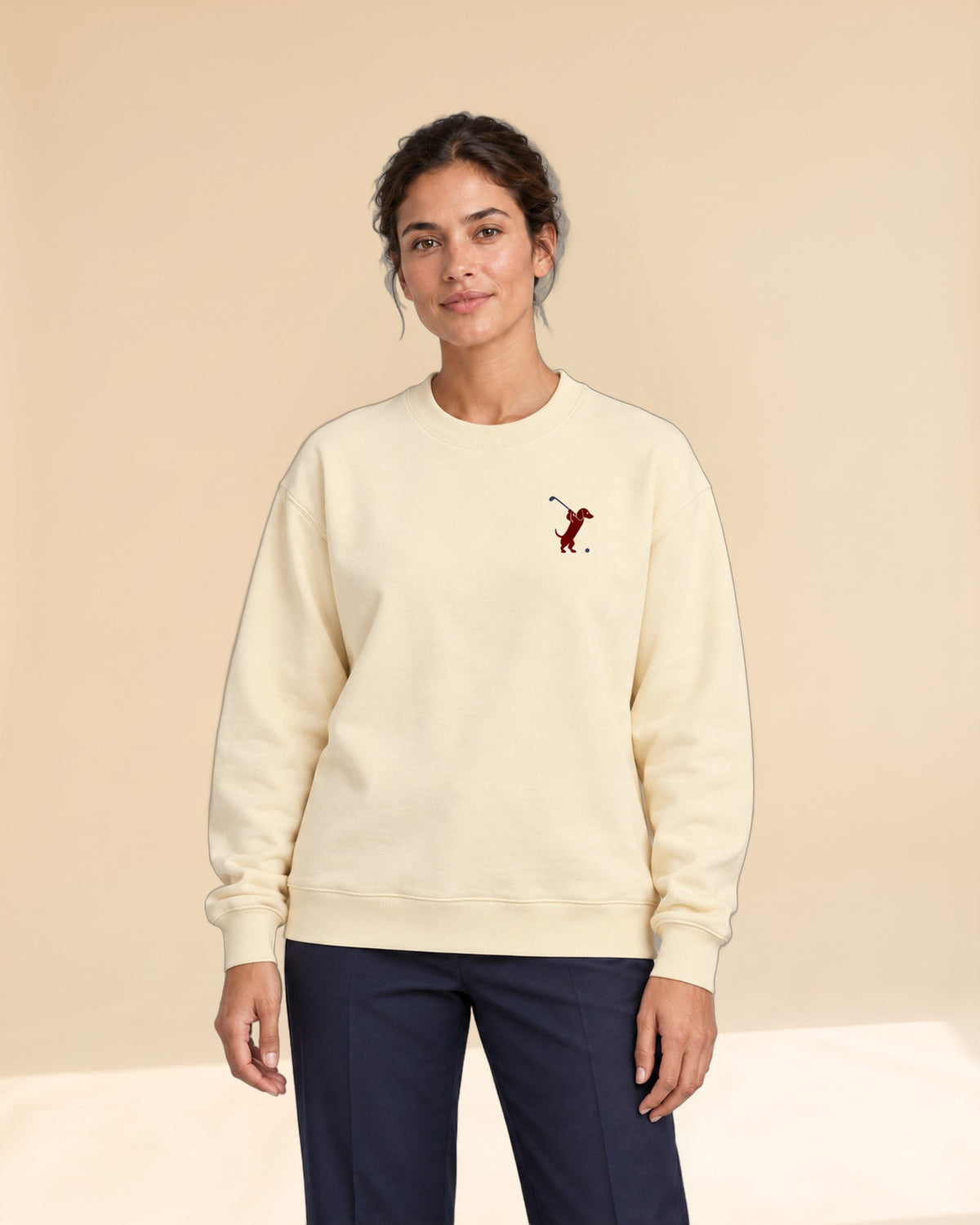 Woman wearing Swing dachshund golf sweatshirt, front studio view. Color: Apricot