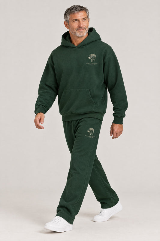 Man walking in The Long Drive dachshund golf hoodie and sweatpants set in Blackish Green. Color: Blackish Green