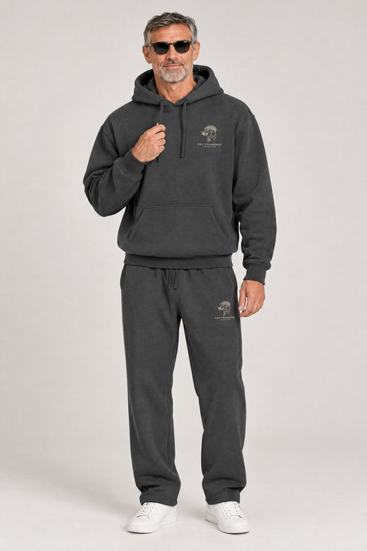 Man wearing The Long Drive dachshund golf hoodie and matching Underdog Golf Club sweatpants in Dark Gray, front view. Color: Dark Gray