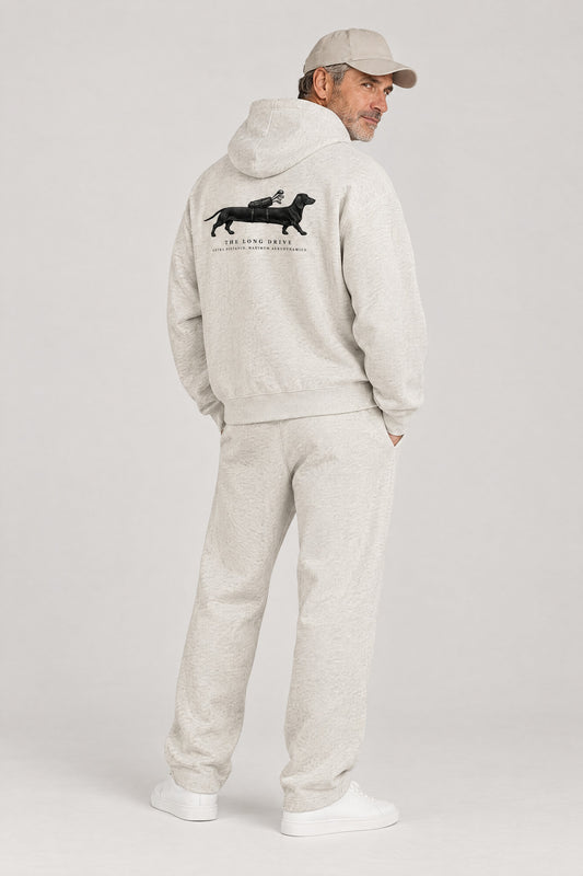 Man seen from behind in The Long Drive dachshund golf hoodie in Oat Gray, showing the large back print. Color: Oat Gray