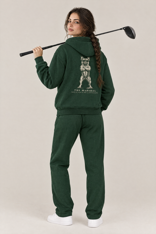 Woman with a driver over her shoulder, back view of The Marshal French Bulldog golf hoodie in Blackish Green with the large back print. Color: Blackish Green