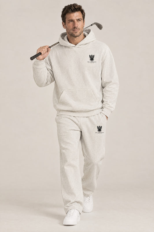 Man walking in The Marshal French Bulldog golf hoodie and sweatpants set in Oat Gray. Color: Oat Gray