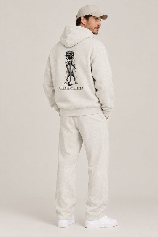 Man seen from behind in The Heavy Hitter pug golf hoodie in Oat Gray, showing the large back print. Color: Oat Gray