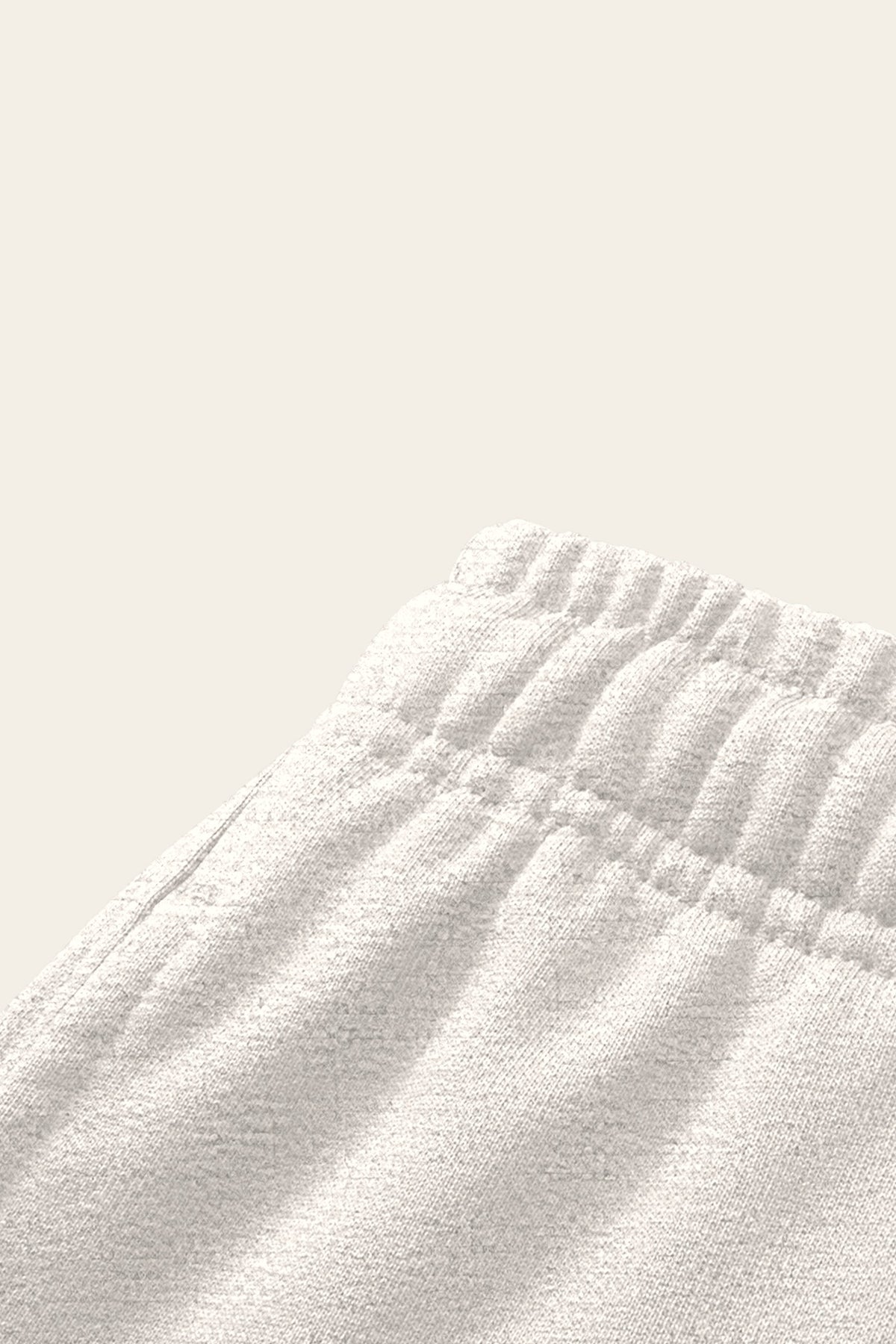 Detail of the elastic waistband and side pocket of the oat gray Underdog Golf Club sweatpants. Color: Oat Gray