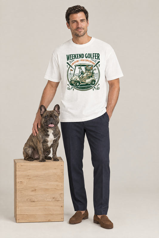 Man wearing the Weekend Golfer French Bulldog Golf Tee in white with a brindle French bulldog on a crate. Color: White