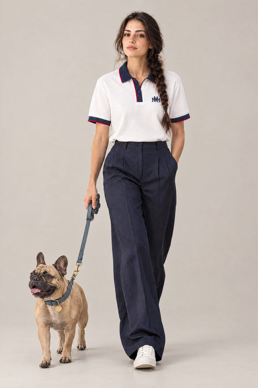 Woman in the white Club Crest color block polo walking a French Bulldog in the dove grey Cloud 7 Tiergarten collar and leash