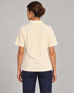 Woman wearing Putting dachshund golf polo, back studio view. Color: Apricot