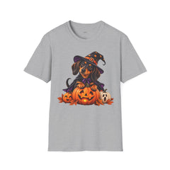 A heather gray short-sleeve crewneck t-shirt featuring a colorful graphic of a dachshund dressed as a witch sitting on jack-o'-lanterns, displayed against a solid white background.