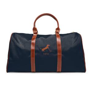 Color: Navy. Putting Dachshund golf travel bag in navy with a brown putting dachshund and MVM monogram on the front, brown PU handles, front view.