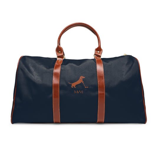 Color: Navy. Putting Dachshund golf travel bag in navy with a brown putting dachshund and MVM monogram on the front, brown PU handles, front view.
