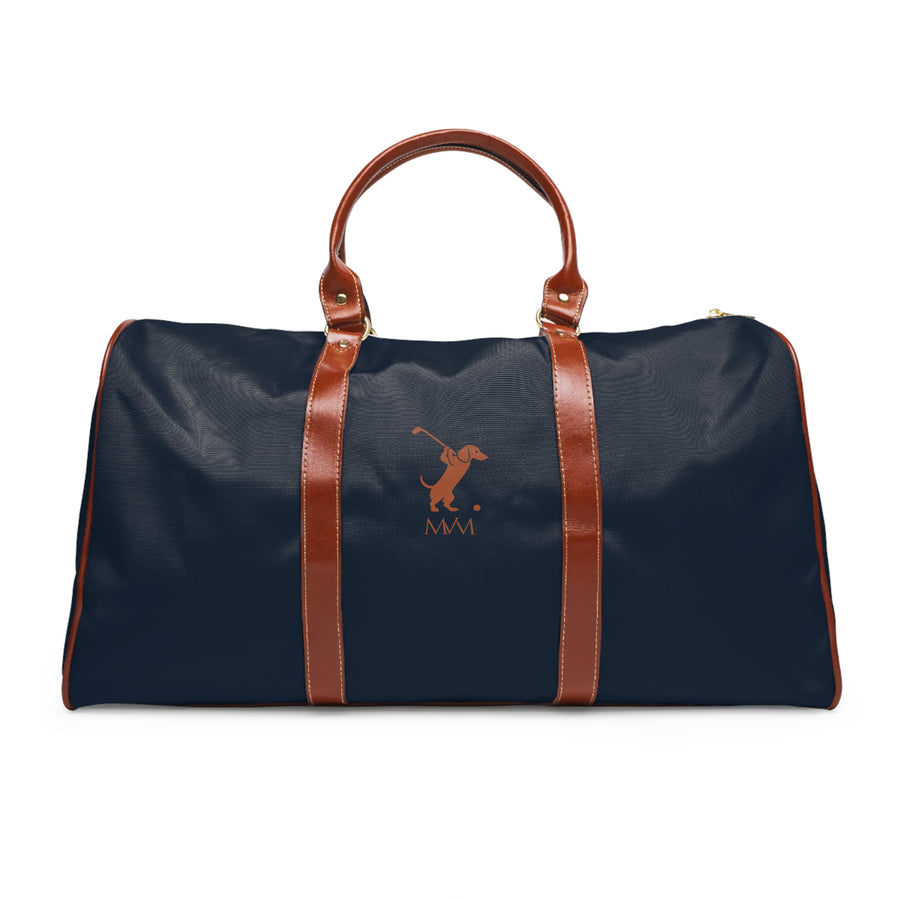 Color: Navy. Swing Dachshund golf travel bag in navy with a brown swinging dachshund and MVM monogram on the front, brown PU handles, front view.