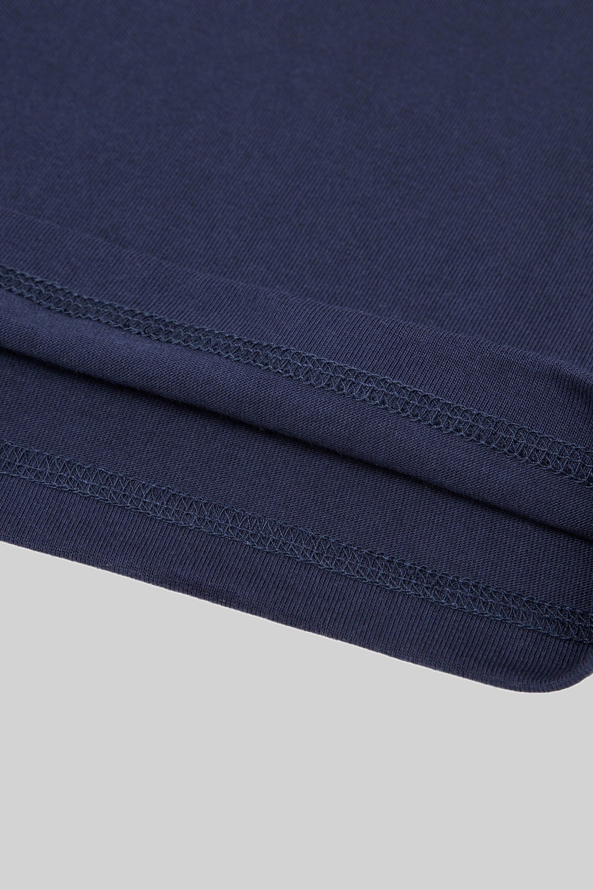 Double-stitched hem of the navy heavyweight cotton tee, close-up