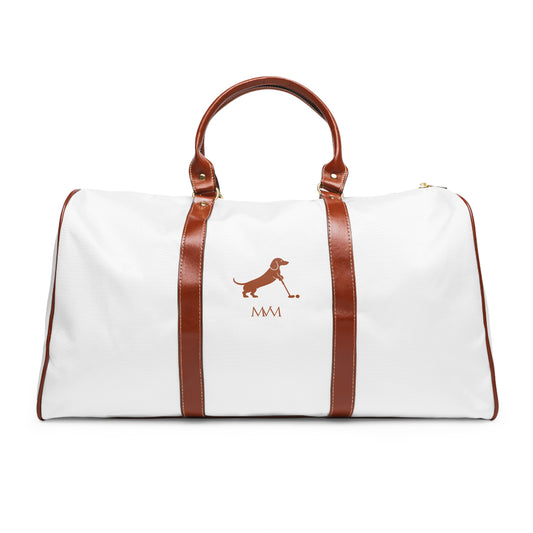 Color: White. Putting Dachshund golf travel bag in white with a brown putting dachshund and MVM monogram on the front, brown PU handles, front view.