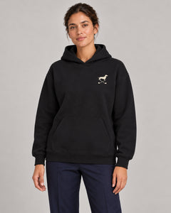Woman wearing Club & Swing dachshund golf hoodie, front studio view. Color: Black