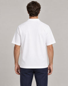 Man wearing Putting dachshund golf polo, back studio view. Color: White