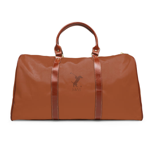 Color: Cognac. Swing Dachshund golf travel bag in cognac with a tonal brown swinging dachshund and MVM monogram, front view.